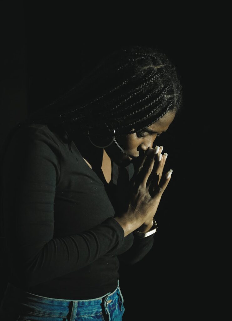 a woman in a black shirt is holding her hands together